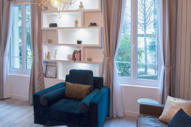 Modelo de biblioteca en casa abierta contemporánea con paredes blancas, suelo de madera clara y televisor independiente