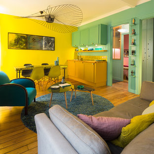 Idée de décoration pour un salon vintage de taille moyenne et ouvert avec un mur jaune, un sol en bois brun, aucune cheminée et aucun téléviseur.