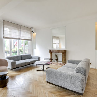 Aménagement d'un salon contemporain ouvert avec une salle de réception, un mur blanc, un sol en bois clair, une cheminée standard, un manteau de cheminée en pierre, aucun téléviseur et un sol beige.