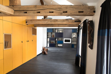 Modelo de biblioteca en casa cerrada actual con paredes blancas, suelo de madera oscura, televisor retractable y suelo negro