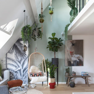 Offenes Modernes Wohnzimmer mit grüner Wandfarbe, hellem Holzboden und beigem Boden in Paris