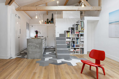 Große, Fernseherlose Moderne Bibliothek ohne Kamin mit weißer Wandfarbe und braunem Holzboden in Paris