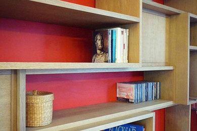 Réalisation d'un grand salon design avec une bibliothèque ou un coin lecture, un mur rouge, un sol en bois brun et un sol marron.