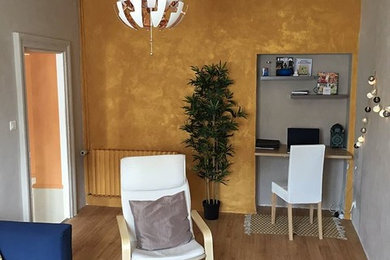 Aménagement d'un petit salon scandinave fermé avec un mur jaune, parquet clair, aucune cheminée et un téléviseur fixé au mur.