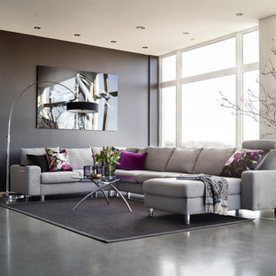 Exemple d'un salon tendance ouvert et de taille moyenne avec un mur noir, béton au sol, aucune cheminée et aucun téléviseur.