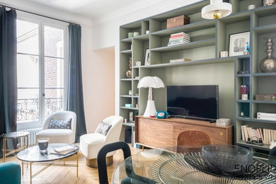 Idée de décoration pour un salon vintage de taille moyenne et ouvert avec une bibliothèque ou un coin lecture, un mur vert, parquet clair, aucune cheminée, un téléviseur indépendant et un sol marron.