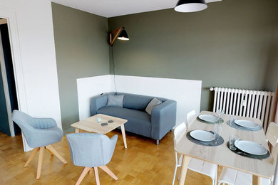 Cette image montre un salon minimaliste de taille moyenne et ouvert avec un mur vert, parquet clair, un téléviseur indépendant et un sol beige.