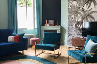 パリにある中くらいなコンテンポラリースタイルのおしゃれなリビング (淡色無垢フローリング、コーナー設置型暖炉、漆喰の暖炉まわり、据え置き型テレビ、ベージュの床、青い壁) の写真