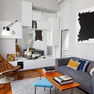 Cette photo montre un salon tendance fermé avec un mur gris et un sol en bois brun.