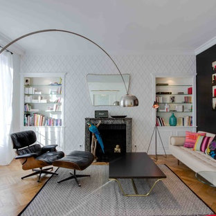 Aménagement d'un salon avec une bibliothèque ou un coin lecture contemporain de taille moyenne et ouvert avec un mur blanc, un sol en bois brun, une cheminée standard, un manteau de cheminée en pierre et aucun téléviseur.