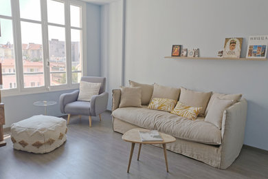 Diseño de salón abierto escandinavo de tamaño medio sin chimenea con paredes azules, suelo laminado, televisor colgado en la pared y suelo gris