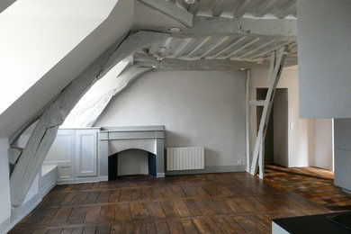 Aménagement d'un salon mansardé ou avec mezzanine classique de taille moyenne avec un sol en bois brun, une cheminée standard, un manteau de cheminée en bois et poutres apparentes.