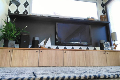 ボルドーにあるお手頃価格の中くらいな北欧スタイルのおしゃれな独立型リビング (黒い壁、コンクリートの床、壁掛け型テレビ、ベージュの床) の写真