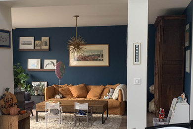 Cette image montre un salon minimaliste de taille moyenne et ouvert avec un mur bleu, sol en stratifié, aucune cheminée et aucun téléviseur.