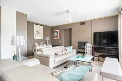 Modelo de salón abierto contemporáneo grande con paredes beige, todas las chimeneas, televisor independiente y suelo beige