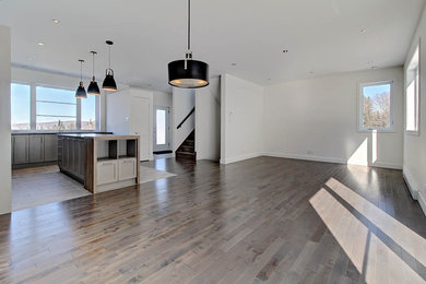 Modelo de salón abierto contemporáneo de tamaño medio sin televisor con paredes blancas y suelo de madera oscura