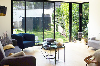 Aménagement d'un salon contemporain de taille moyenne et ouvert avec un mur blanc, parquet clair et un sol marron.