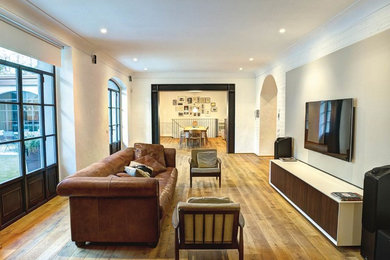 Foto de salón cerrado moderno de tamaño medio con suelo de madera clara y suelo marrón