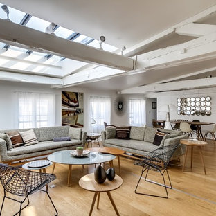 Réalisation d'un grand salon bohème ouvert avec un mur blanc, un sol en bois clair, une salle de réception, aucune cheminée et aucun téléviseur.