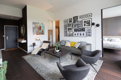 Exemple d'un salon tendance ouvert avec un mur blanc, parquet foncé et un sol marron.