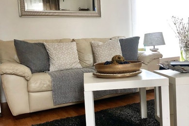 Immagine di un soggiorno moderno di medie dimensioni e chiuso con libreria, pareti bianche, pavimento in legno massello medio, TV autoportante e pavimento marrone