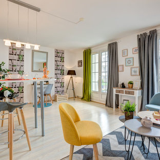 Aménagement d'un salon éclectique ouvert avec un mur blanc, un sol en bois clair et un sol beige.
