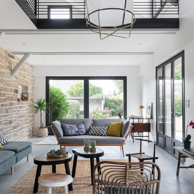 Example of a large danish open concept gray floor living room design in Nantes with white walls