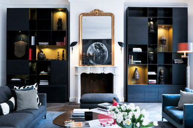 パリにあるお手頃価格の広いトラディショナルスタイルのおしゃれなLDK (ライブラリー、白い壁、濃色無垢フローリング、標準型暖炉、石材の暖炉まわり、内蔵型テレビ、グレーの床) の写真
