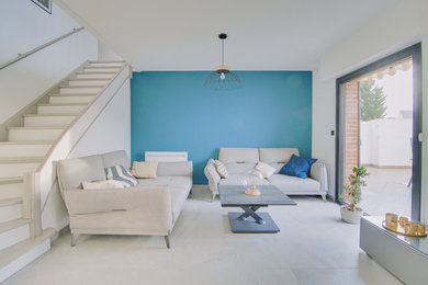 Idées déco pour un salon contemporain de taille moyenne et ouvert avec un mur bleu, un sol en carrelage de céramique, un téléviseur indépendant et un sol gris.