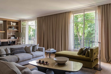 Mittelgroßes, Abgetrenntes Modernes Wohnzimmer mit weißer Wandfarbe, hellem Holzboden, Kamin, Kaminumrandung aus Beton und braunem Boden in Nizza