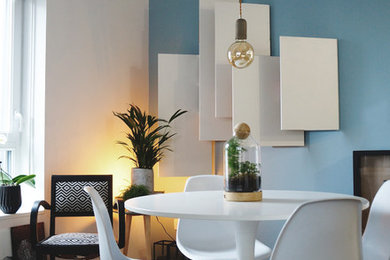 Medium sized scandinavian dining room with blue walls, light hardwood flooring and beige floors.