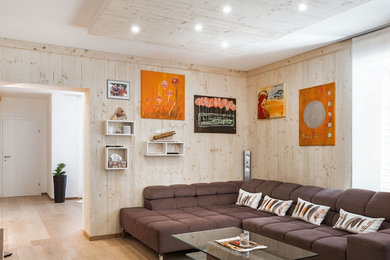 Cette photo montre un salon tendance fermé avec un mur beige, parquet clair et un sol beige.