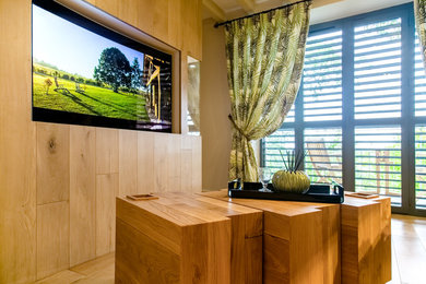 Imagen de salón cerrado actual grande con paredes blancas, suelo de madera clara, televisor retractable y suelo beige