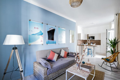 Réalisation d'un salon marin de taille moyenne et ouvert avec un mur bleu et un sol en vinyl.