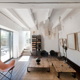 Cette image montre un grand salon avec une bibliothèque ou un coin lecture design fermé avec un mur blanc, un sol en bois foncé, aucune cheminée et aucun téléviseur.