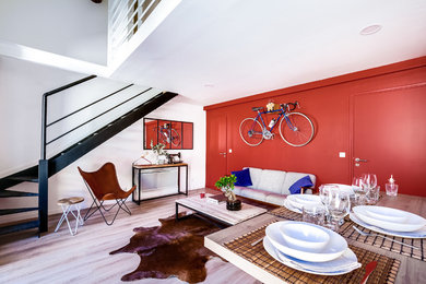 Exemple d'un salon mansardé ou avec mezzanine tendance de taille moyenne avec un bar de salon, un mur rouge, un sol en vinyl, aucune cheminée et un téléviseur fixé au mur.