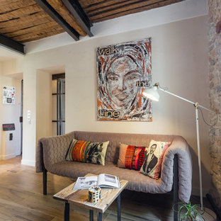 Cette photo montre un salon méditerranéen de taille moyenne et ouvert avec une salle de réception, un mur beige, un sol en bois clair, aucune cheminée et aucun téléviseur.