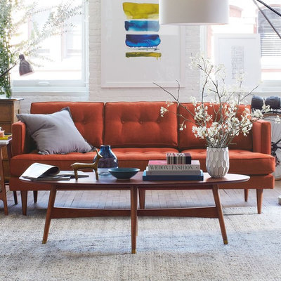 Example of a large danish enclosed medium tone wood floor living room design in London with white walls, no fireplace and no tv