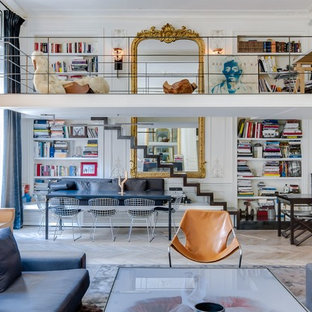 Exemple d'un salon avec une bibliothèque ou un coin lecture éclectique de taille moyenne et ouvert avec un mur blanc, un sol en bois clair, aucune cheminée et aucun téléviseur.