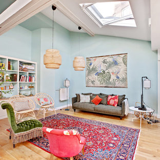 Réalisation d'un grand salon ethnique ouvert avec un sol en bois brun, un sol marron, un mur bleu et aucun téléviseur.