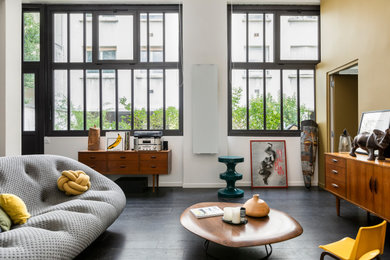 Offenes Modernes Wohnzimmer mit weißer Wandfarbe, dunklem Holzboden und schwarzem Boden in Paris