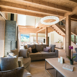 Cette photo montre un salon montagne ouvert avec un sol en bois clair, aucune cheminée et un sol beige.