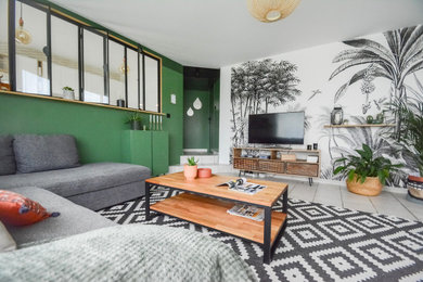 Aménagement d'un salon contemporain ouvert avec un mur vert, un téléviseur indépendant, un sol beige et du papier peint.