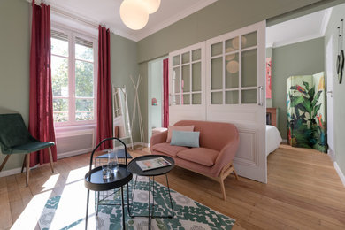 Cette photo montre un salon tendance avec un mur vert et parquet clair.