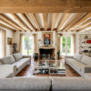 Großes, Fernseherloses, Abgetrenntes, Repräsentatives Country Wohnzimmer mit Terrakottaboden, weißer Wandfarbe, Kamin und Kaminumrandung aus Stein in Paris