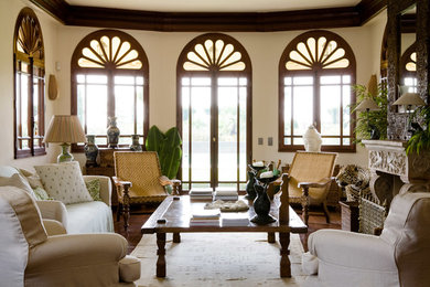 Diseño de salón tropical con paredes beige y suelo de madera oscura