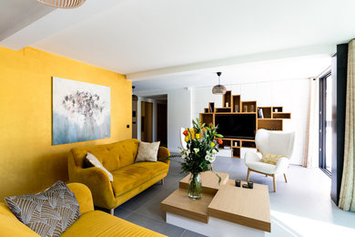 Idée de décoration pour un grand salon design ouvert avec une bibliothèque ou un coin lecture, un mur jaune, un sol en carrelage de céramique, un téléviseur encastré et un sol gris.