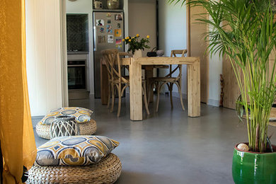 Cette image montre un salon méditerranéen avec un mur gris et sol en béton ciré.