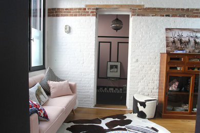 Modelo de salón cerrado moderno de tamaño medio con paredes blancas, suelo de madera clara y suelo beige