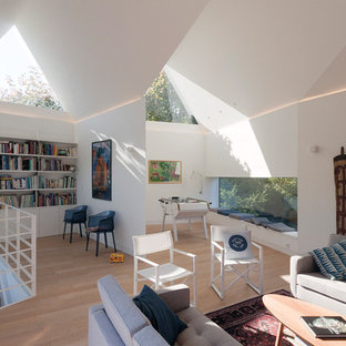 Réalisation d'un grand salon design avec un mur blanc, un sol en bois clair, aucune cheminée et aucun téléviseur.